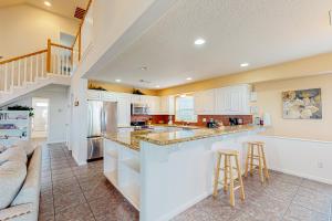 a kitchen with white cabinets and a large island at Sea Breeze in Galveston