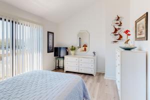 Schlafzimmer mit einem Bett, einer Kommode und einem Spiegel in der Unterkunft The Coral Starfish #10J in Ocean City