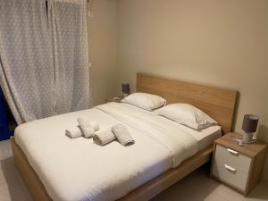 a bedroom with a bed with two towels on it at Amalfi Complex in Kato Almiri
