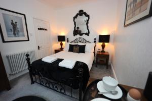 a bedroom with a black and white bed and a table at Bryn Derwen in Caernarfon