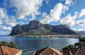 a view of the water with a mountain in the background at Marea in Palermo