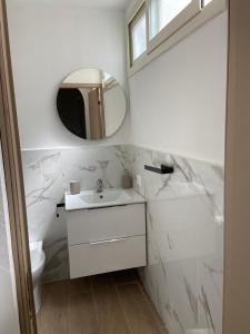 un bagno bianco con lavandino e specchio di Marea a Palermo