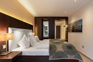 een slaapkamer met een groot wit bed en een lamp bij Hotel Residenz Passau in Passau