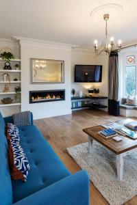 a living room with a blue couch and a fireplace at Wharfedale Retreat in Ilkley