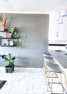 a kitchen with gray walls and stools at Home away from home in Centurion