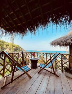 a deck with two chairs and a table and the ocean at Life's A Beach in Quy Nhon