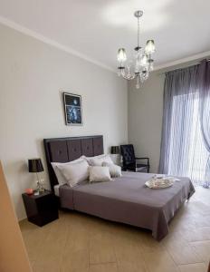 a bedroom with a large bed and a chandelier at Villa Archontia Family House!!! in Preveza