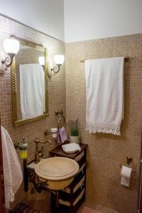 een badkamer met een wastafel, een spiegel en handdoeken bij Villa Archontia Family House!!! in Preveza