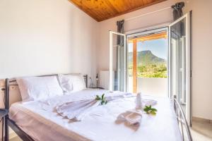 1 dormitorio con cama blanca y ventana grande en Olive Apartment near the Beach, en Gázion