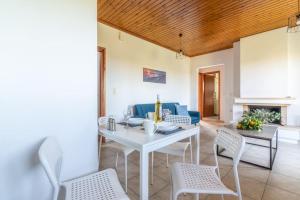 a living room with a white table and chairs at Olive Apartment near the Beach in Gázion