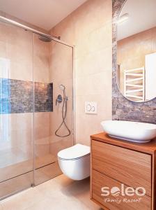a bathroom with a shower and a toilet and a sink at Apartament Dwupoziomowy SUPERIOR z 2-sypialniami i klimatyzacją - SOLEO Family Resort in Rewal