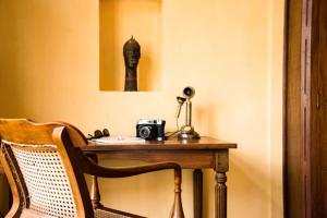 un tavolo con una macchina fotografica e una foto di una testa di Old Harbour Hotel a Cochin