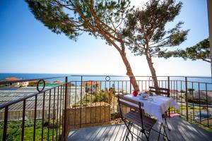 balcone con tavolo e vista sull'oceano di Casa Bart a Cipressa