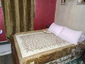 uma pequena cama com almofadas brancas em City Hostel no Cairo