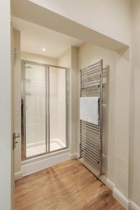 uma casa de banho com um chuveiro e uma porta de vidro em Wharfedale Retreat em Ilkley