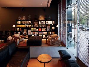 a living room with a couch and a book shelf at Hotel Ismael - Lastarria in Santiago