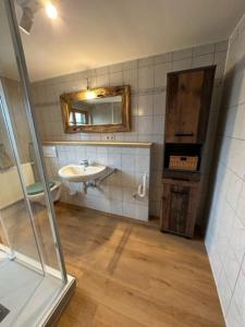 a bathroom with a sink and a toilet and a mirror at Charmante farbenfrohe Wohnung für zwei in Fischbachau