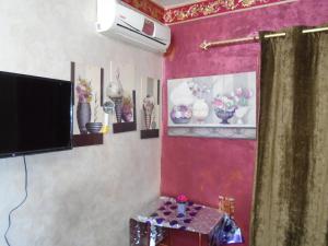 a living room with a tv and flowers on the wall at City Hostel in Cairo