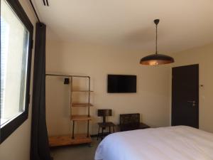 1 dormitorio con 1 cama, TV y ventana en D'OR Les Anges en Les Angles Gard