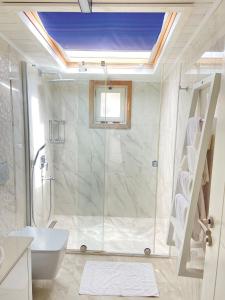 a bathroom with a shower and a toilet and a sink at Narr Hotel in Kaş