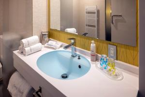 洞爷湖HOTEL COCOA RESORT的带蓝色水槽和镜子的浴室