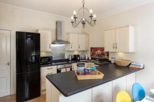 a kitchen with a black refrigerator and a black counter top at Wharfedale Retreat in Ilkley