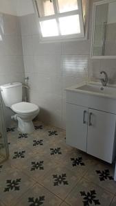 a bathroom with a toilet and a sink at חלון למדבר in Arad