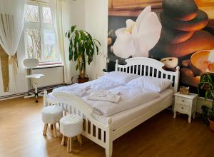 Beauty-Spa Apartment في ديشين: غرفة نوم بسرير أبيض مع لوحة كبيرة على الحائط