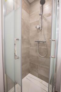 uma cabina de duche com uma porta de vidro e um chuveiro em Cosmo ideal famille rue Carnot em Annecy