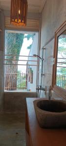 uma casa de banho com um lavatório e uma grande janela em Tribal Green Camp Private Room 1 em SantʼAna