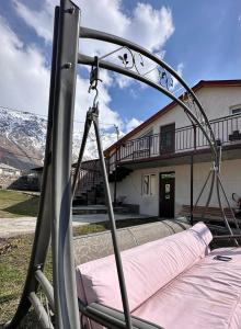 a swing bed in front of a house at Guest house chavchavadze N23 in Stepantsminda