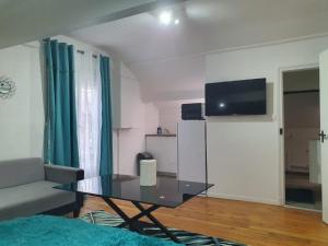 a living room with a glass table and a tv at Joli studio/Bourget/CDG/PARIS in Aulnay-sous-Bois