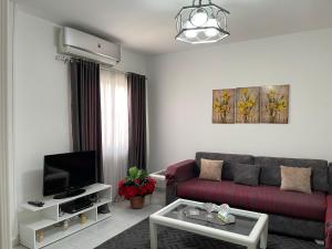 sala de estar con sofá rojo y TV en City Center Apartment - Neama Bay, en Sharm El Sheikh