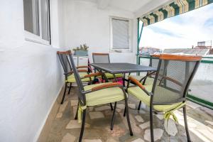a table and chairs on a balcony with a window at Apartments Ercegovic in Rogoznica