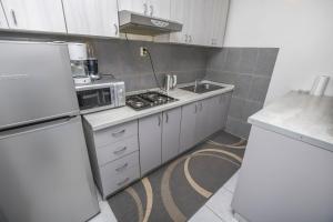 a small kitchen with a microwave and a sink at Apartments Ercegovic in Rogoznica