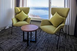 2 sillas y una mesa en una habitación con ventana grande en HOTEL COCOA RESORT, en Lago Toya