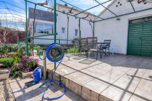 a patio with a fan and a table and chairs at Apartments Ercegovic in Rogoznica