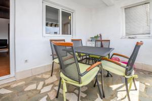a table and chairs in a room at Apartments Ercegovic in Rogoznica