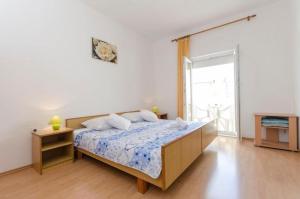 a bedroom with a bed and a large window at Apartments Anastazija in Vodice