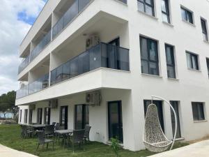 a white building with chairs and tables in front of it at Sahil Aparts - Güllük in Milas