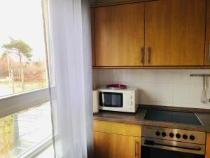 a kitchen with a microwave on a counter next to a window at Ostseeresidenz - Whg 15 Ostseeblick in Zingst