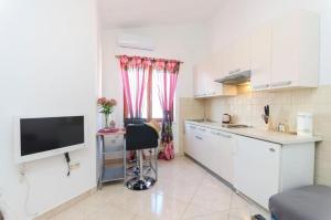 a small kitchen with a desk and a tv in it at Apartment Marija in Vodice