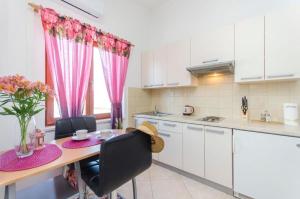 a kitchen with a wooden table with chairs and a dining room at Apartment Marija in Vodice