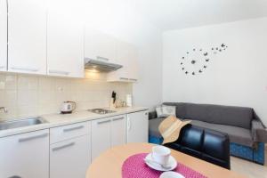 a kitchen and living room with a table and a couch at Apartment Marija in Vodice