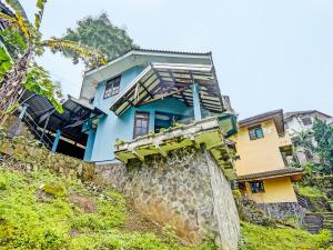 een blauw huis bovenop een heuvel bij SPOT ON 92388 Villa Segi Delapan in Prigen