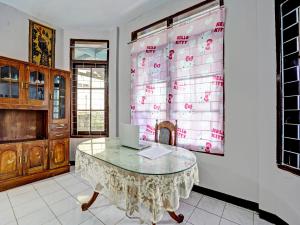 een kamer met een tafel en een laptop erop bij SPOT ON 92388 Villa Segi Delapan in Prigen