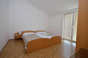 een slaapkamer met een groot bed en een raam bij Apartments Zlatko in Jadrtovac