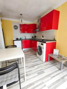 a kitchen with red cabinets and a washing machine at Apartamento en Calle Heraclio Sánchez in Las Lagunas