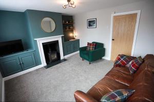 a living room with a couch and a fireplace at Auctioneers Cottage in Louth