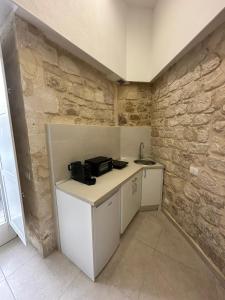 una piccola cucina con bancone e muro in pietra di Mastranza 20 a Scicli
